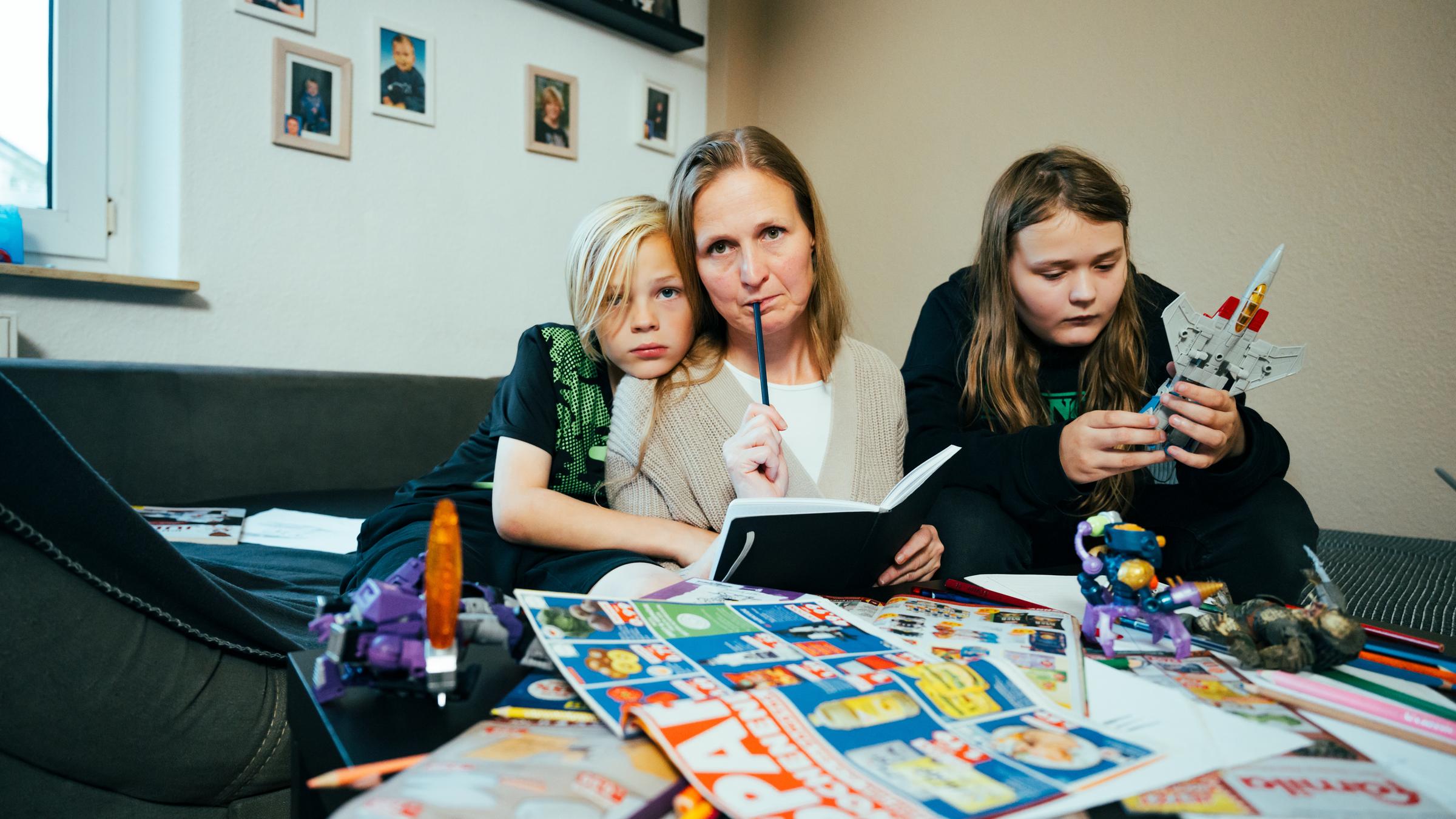 "Eine für alles - Armutsrisiko alleinerziehender Mutter": Cindy sitzt mit zwei ihrer vier Kinder zu Hause in ihrer Wohnung in Oldenburg auf dem Sofa.