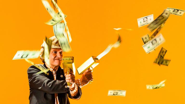 "Beim Pelzig auf der Bank - Scheiss Geld - Wie werd‘ ich reich?": Herr Pelzig schießt mit einer Geldpistole Banknoten in die Luft.
