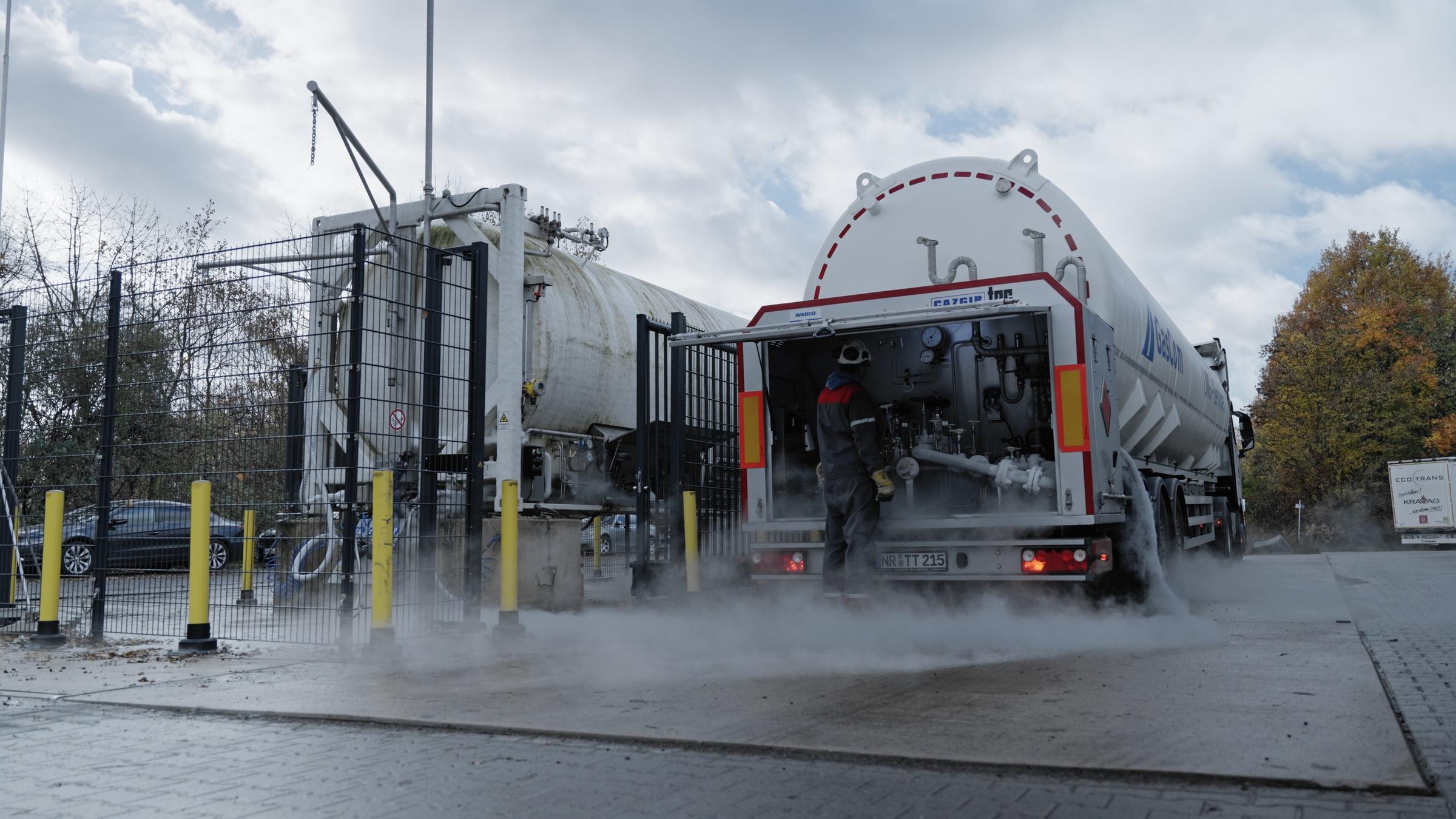 "ZDFzoom: LNG: Zu viel, zu teuer, schlecht fürs Klima - Ist der Flüssiggas-Boom ein Irrweg?": Mann in Arbeitsmontur steht vor aufgeklapptem hinteren Teil eines Tankwagens.