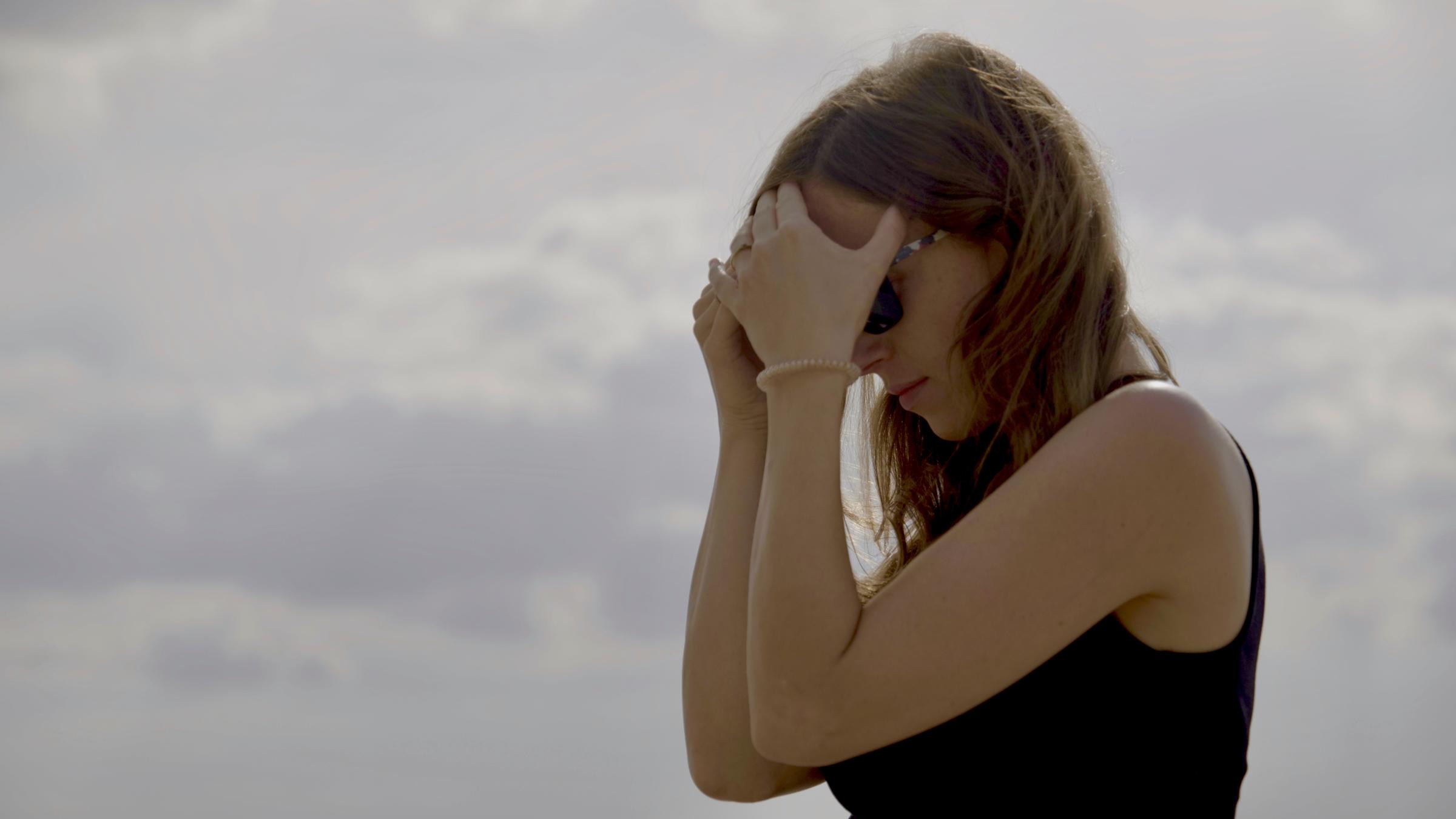 "Mir platzt der Kopf - Leben mit Migräne": Birte greift sich mit beiden Händen an die Stirn.