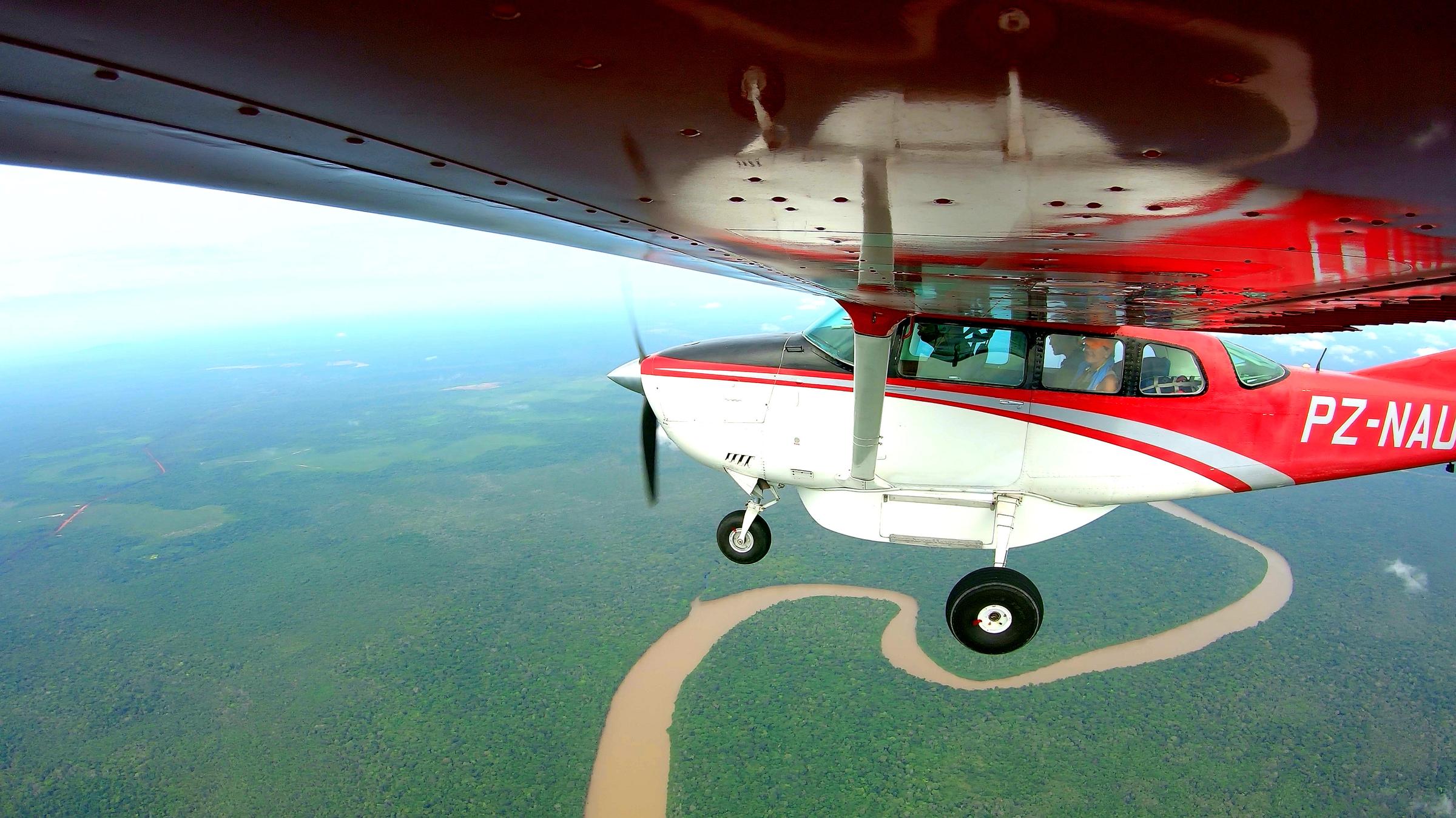 "Terra X: Buschflieger - Abenteurer am Himmel": Ein rotes Wasserflugzeug fliegt über dem grünen Amazonas.