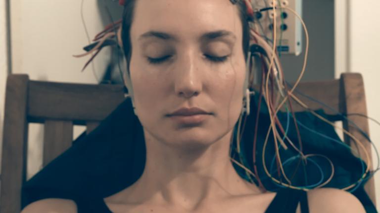 "Heil Dich doch selbst": Nahaufnahme vom Kopf einer jungen Frau, an dem die Kabel eines Elektroenzephalogramms befestigt sind.