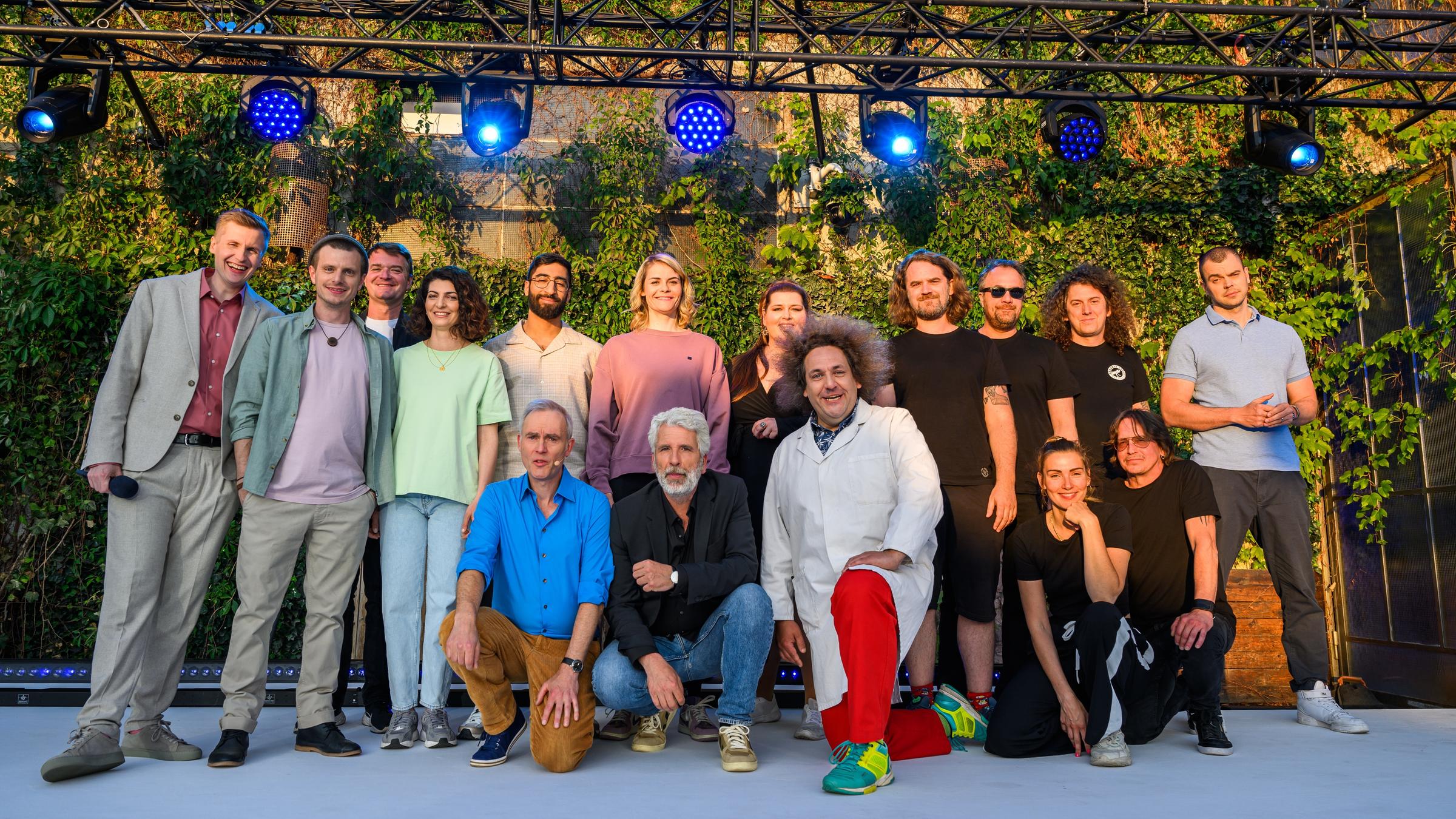 "Till Reiners` Happy Hour XXL - Die Sommerparty": Gruppenbild mit dem Moderator und allen Künstlern: hinten Till Reiners, Moritz Neumeier, Bandmitglied der Band Madsen, Filiz Tasdan; Kawus Kalantar, Hazel Brugger, Nicole Jäger, Mitglieder der Band Madsen, Nikita Miller, vorrne Johann König, Dirk Stermann, Konrad Stöckel, Band Madsen.