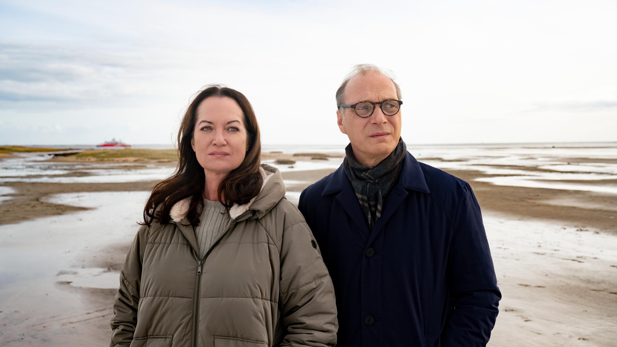 "Unter anderen Umständen - Dämonen": Jana Winter (Natalia Wörner) und Arne Brauner (Martin Brambach) stehen nebeneinander im Watt und schauen in die Ferne.