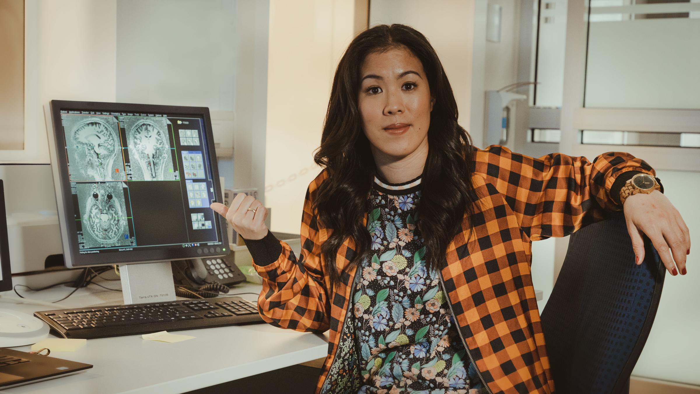 "Terra X: maiBrain: Reise ins Gehirn: Sinne und Bewusstsein": Moderatorin Mai Thi Nguyen-Kim sitzt vor einem Bildschirm mit MRT-Bildern ihres Gehirns.