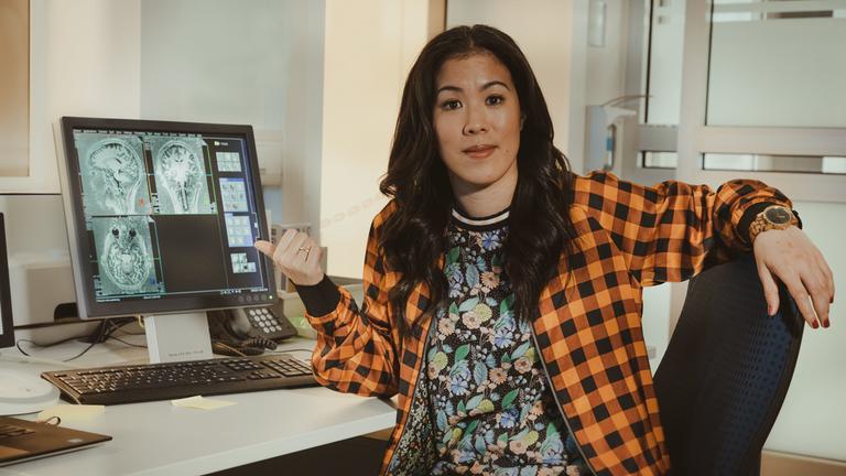 "Terra X: maiBrain: Reise ins Gehirn: Sinne und Bewusstsein": Moderatorin Mai Thi Nguyen-Kim sitzt vor einem Bildschirm mit MRT-Bildern ihres Gehirns.