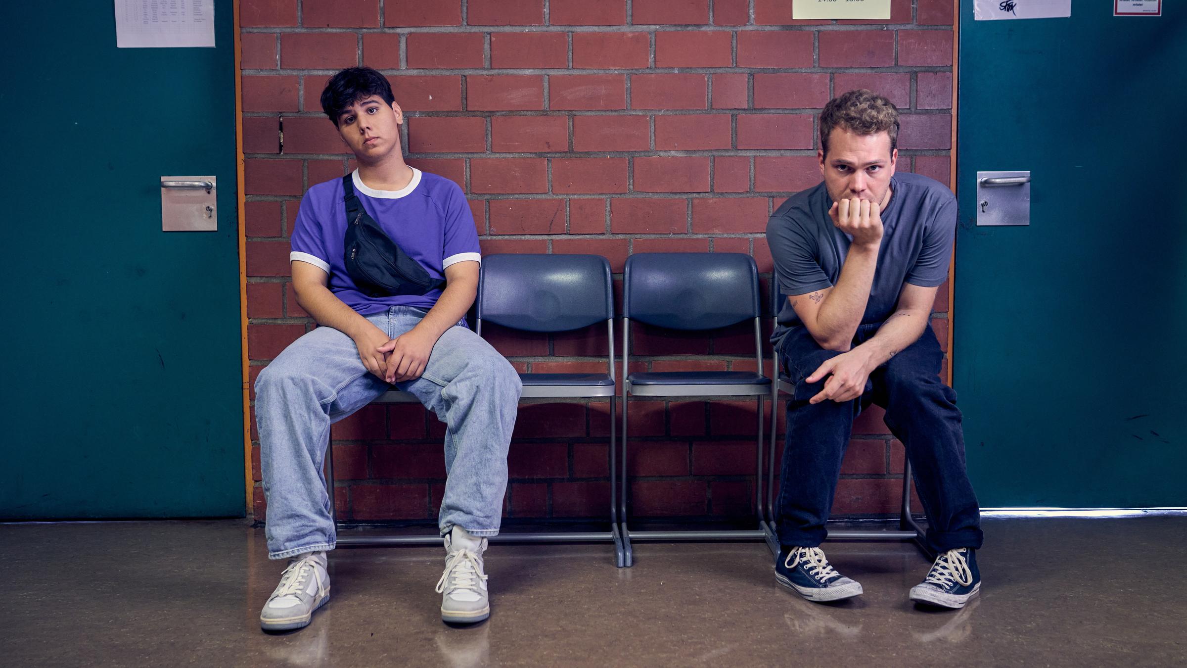 "Like a Loser - Bitterer Ernst": Julian (Ben Münchow) und Ernst (Diyar Ilhan) sitzen vor einem Klassenzimmer.