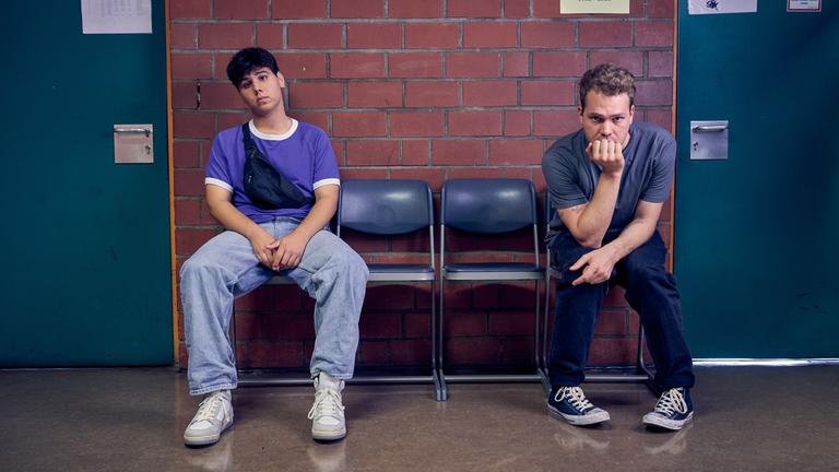 "Like a Loser - Bitterer Ernst": Julian (Ben Münchow) und Ernst (Diyar Ilhan) sitzen vor einem Klassenzimmer.