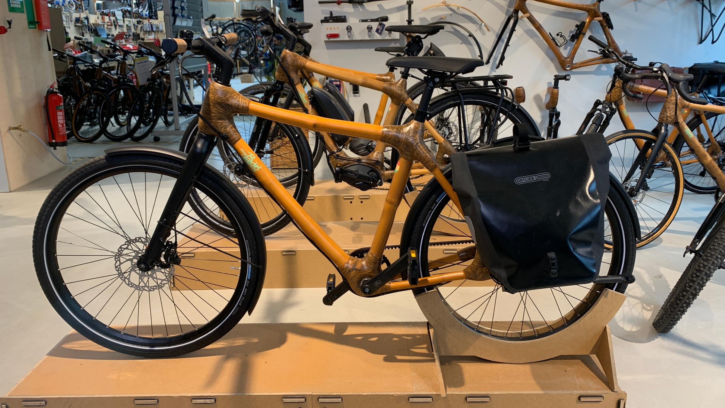 "planet e.: Die Schattenseiten unserer Fahrräder - Wo hakt es bei Klimabilanz und Lieferketten?": Fahrräder aus Bambus stehen in einem Raum.