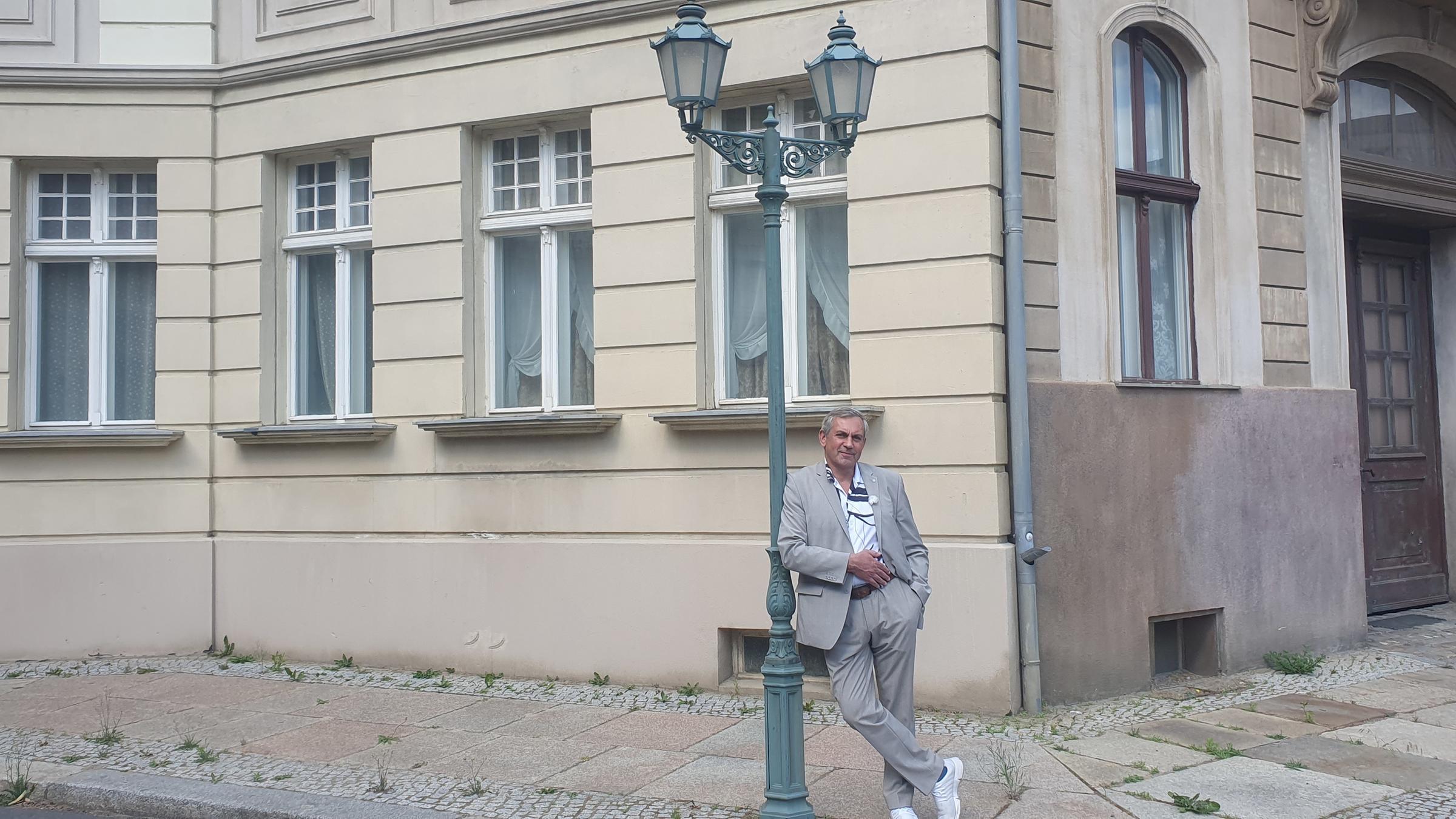 "Kaminer Inside: Filmstadt Babelsberg": Kaminer vor der Kulisse einer Berliner Straßenecke, er lehnt an einer alten Gaslaterne.