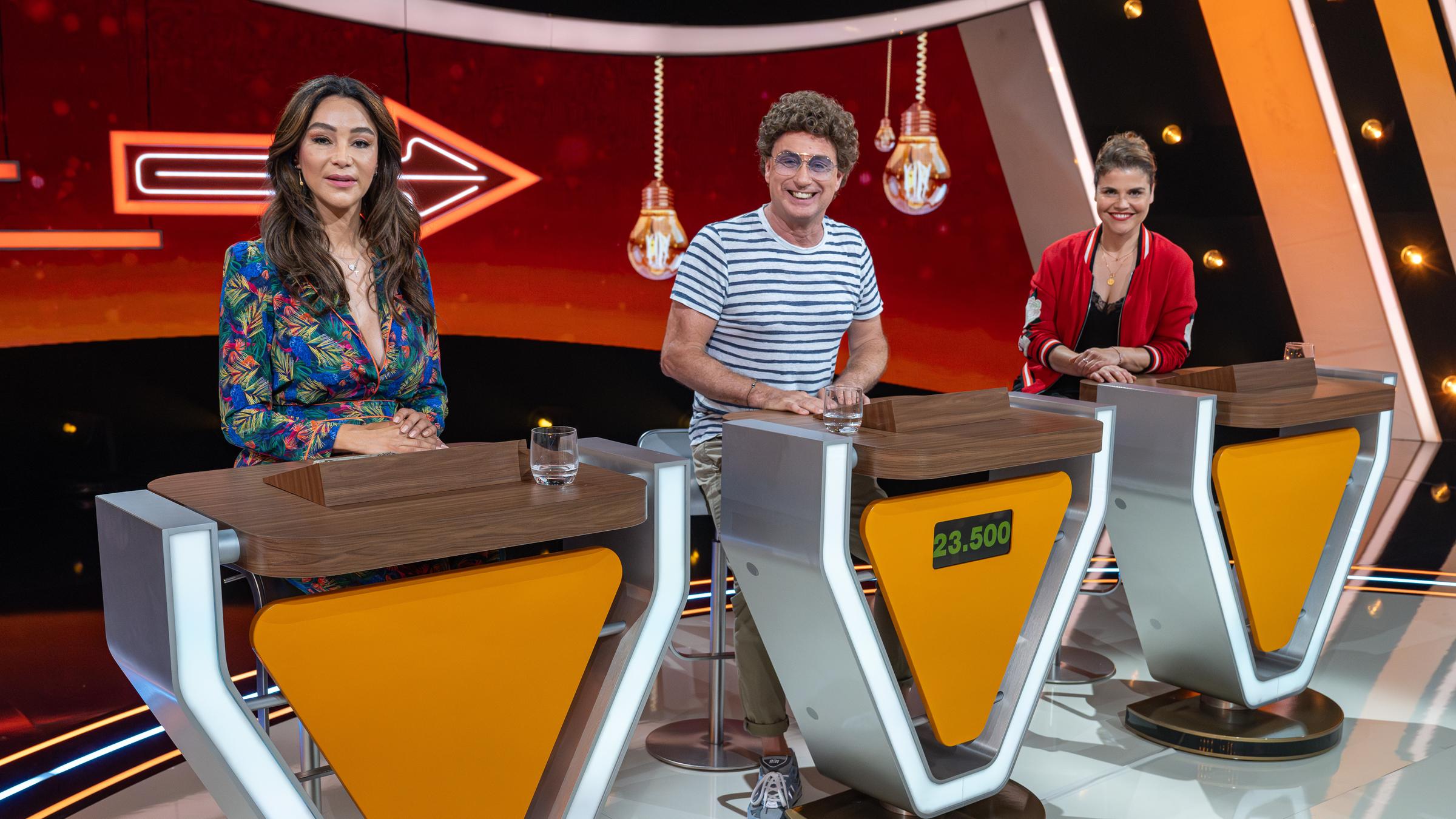 "Da kommst Du nie drauf!": Verona Pooth, Atze Schröder und Katharina Wackernagel sitzen hinter ihren Spielpulten. Sie lächeln und schauen direkt in die Kamera.