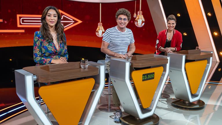 "Da kommst Du nie drauf!": Verona Pooth, Atze Schröder und Katharina Wackernagel sitzen hinter ihren Spielpulten. Sie lächeln und schauen direkt in die Kamera.