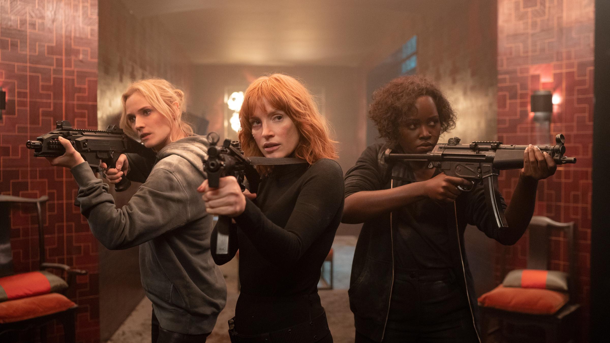"The 355 - Absolute Geheimsache": Marie (Diane Kruger), Mace (Jessica Chastain) und Khadijah (Lupita Nyong'o) stehen mit erhobenen Sturmgewehren nebeneinander in einem rund geschnittenem Raum.