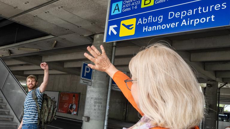 "Aktenzeichen XY... Vermisst": Nachgestellte Szene an einer U-Bahn Station: Ein junger Mann winkt fröhlich seiner Mutter zum Abschied. Er trägt einen Rucksack am Rücken.