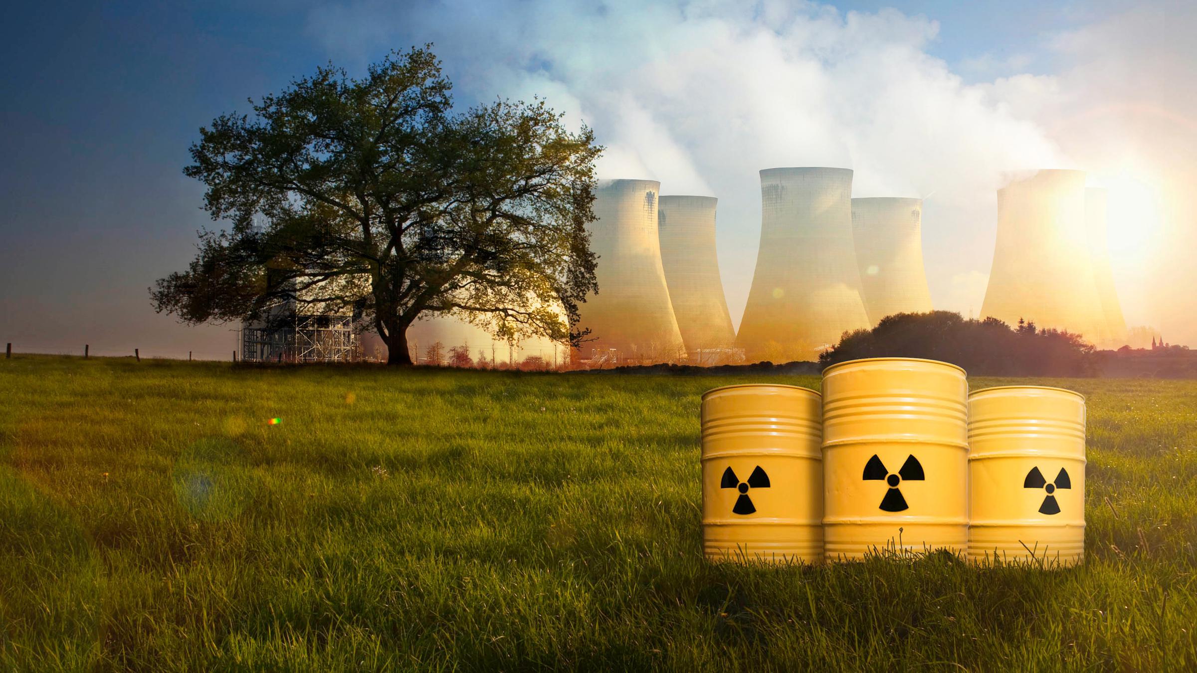 "Das Atomzeitalter – Höllenfeuer und Hoffnung - Von Hiroshima bis zur Kuba-Krise": Montage: Auf einer Wiese stehen im Vordergrund drei Atommülltonnen, im Hintergrund steht links ein Baum und rechts mehrere qualmende Atommeiler.