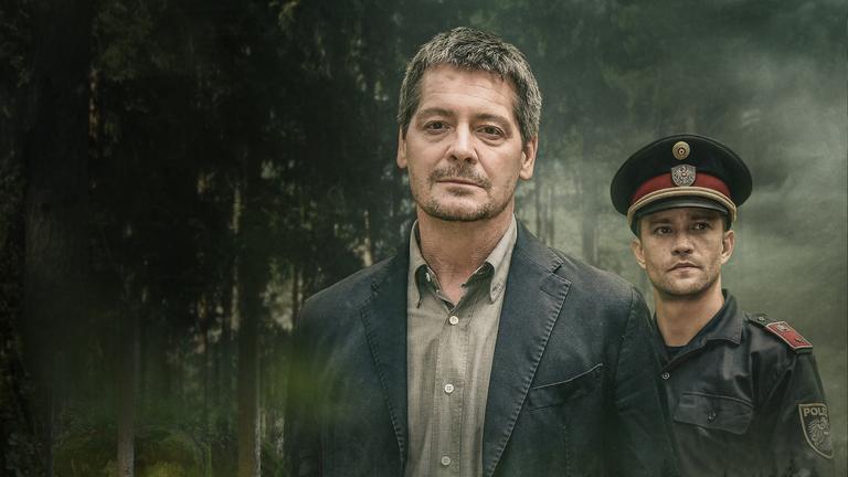 "Der Schutzengel - Ein Landkrimi": Paul Werner (Fritz Karl) und Martin (Michael Steinocher) gehen zusammen durch den Wald