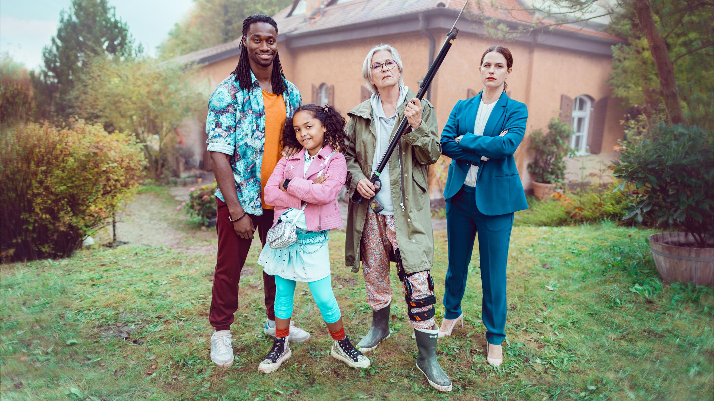  "Mit Harpunen schießt man nicht": Simon (Eugene Boateng), Feli (Muine Keune), Gerda (Gerburg Jahnke) und Linda (Isabell Polak) stehen nebeneinander vor einem Haus im Garten und schauen direkt in die Kamera.