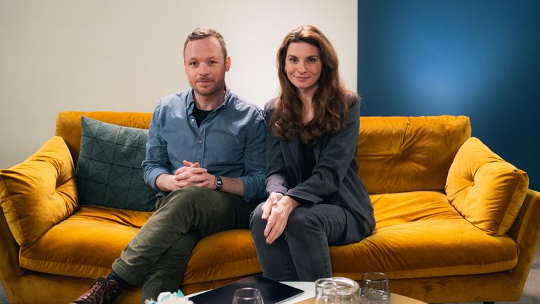 "Kinder der Einheit - Kohle": Judith Poznan und Lukas Weyell sitzen nebeneinander auf dem Sofa und blicken in die Kamera.