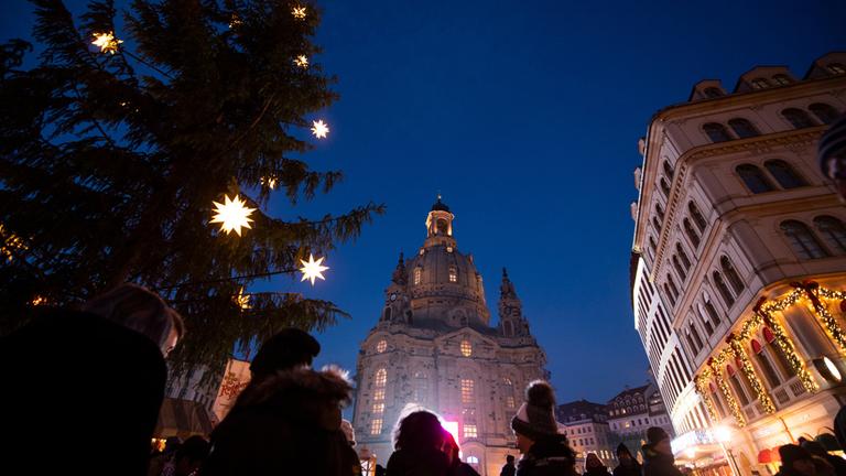 "Adventskonzert aus Dresden": Außenaufnahme der Frauenkirche in Dresden: Blick von unten an der Frauenkirche empor in den nächtlichen Himmel. An der Seite steht ein geschmückter Weihnachtsbaum.