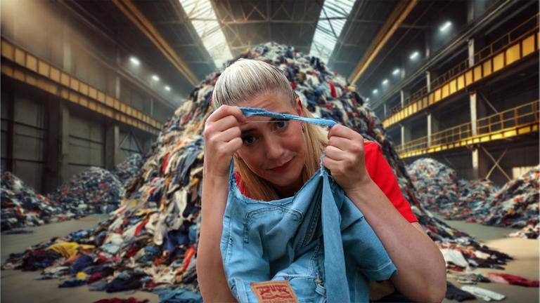 "Nice Price – Die Tricks der Textilindustrie": Pia Osterhaus sitzt vor einem Haufen alter Jeans und schaut durch das Loch einer kaputten Jeans.