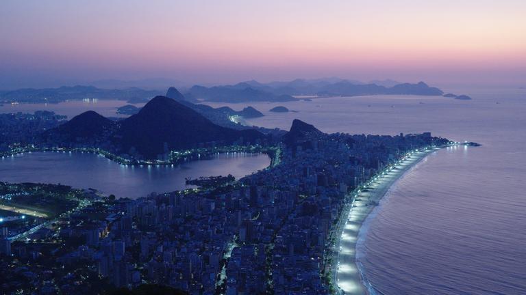 "Megacitys - Wenn es Nacht wird in Rio de Janeiro": Panoramaaufnahme: Die Lichter der Stadt Rio de Janeiro leuchten in der Morgendämmerung.
