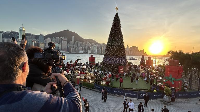 "auslandsjournal - die doku: Weihnachtszauber weltweit - Die ZDF-Korrespondenten zwischen Rauscheengel und Rentier": Weihnachtsinstallationen mit einem großen Weihnachtsbaum am Hafen in Hongkong.