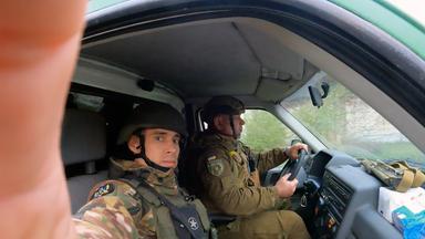 "frontal-Dokumentation: White Angel - Das Ende von Marinka": Der ukrainische Polizist Vasyl Pipa dokumentiert die Rettungseinsätze von "White Angel" in der ostukrainischen Stadt Marinka mit Handy und Helmkamera. Er sitzt auf dem Beifahrersitz im Auto. Neben ihm sitzt ein Kollege, der das Auto steuert.