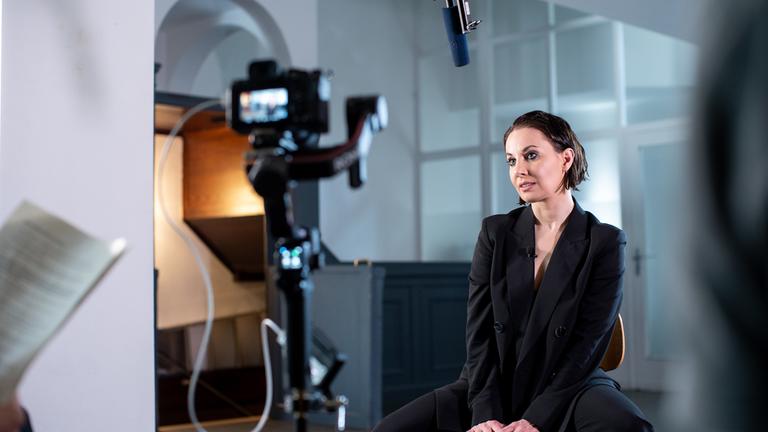"Sex, Macht und Lügen (1/3) - In der Politik": Hanna Lakomy, ganz in schwarz gekleidet, sitzt vor einer Kamera und wird interviewt.