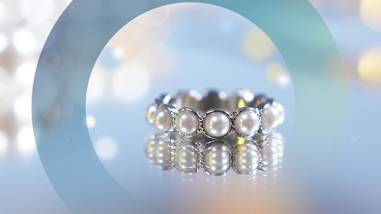 "planet e.: Luxus, Glamour, schöner Schein - Modeschmuck als Massenware": Ein Ring liegt auf einem Spiegel.