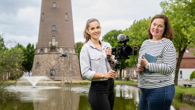 ZDF in Heide: Kamerafrau Melanie Mollenhauer und Reporterin Winnie Heescher in Heide. Im Hintergrund das Fundament eines Leuchtturms