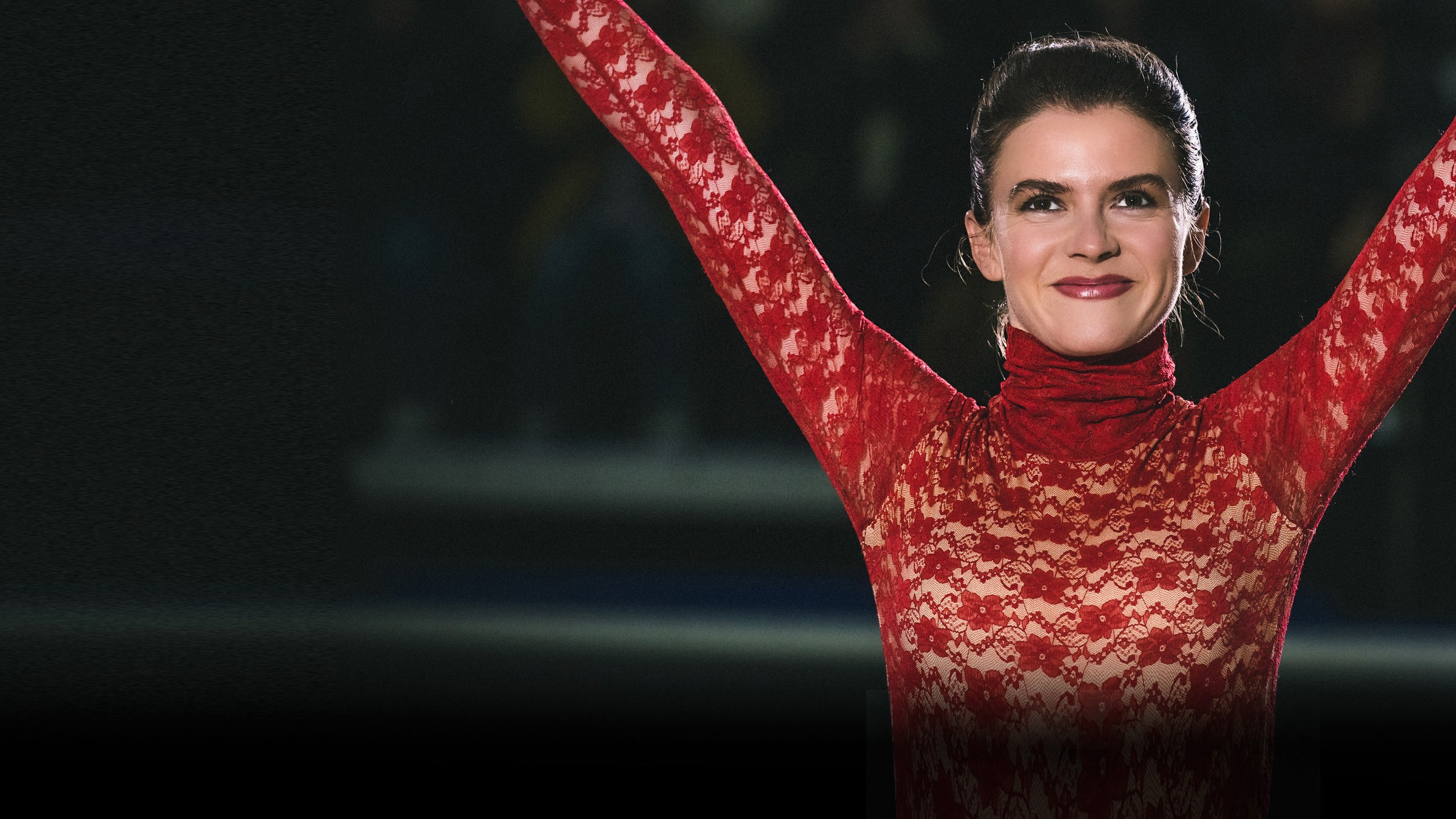 "KATI - Eine Kür, die bleibt": Kati Witt (Lavinia Nowak) steht in Siegerpose mit erhoben Armen und lächelt glücklich. Im Hintergrund kann man schemenhaft die Zuschauer erkennen.