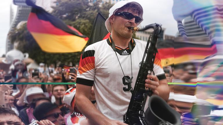 "EM-Partyzone Deutschland: So feiern Fußball-Fans": Im Vordergrund ein Mann mit Saxophon. Im Hintergrund weitere Fußball-Fans und zwei Deutschlandfahnen.