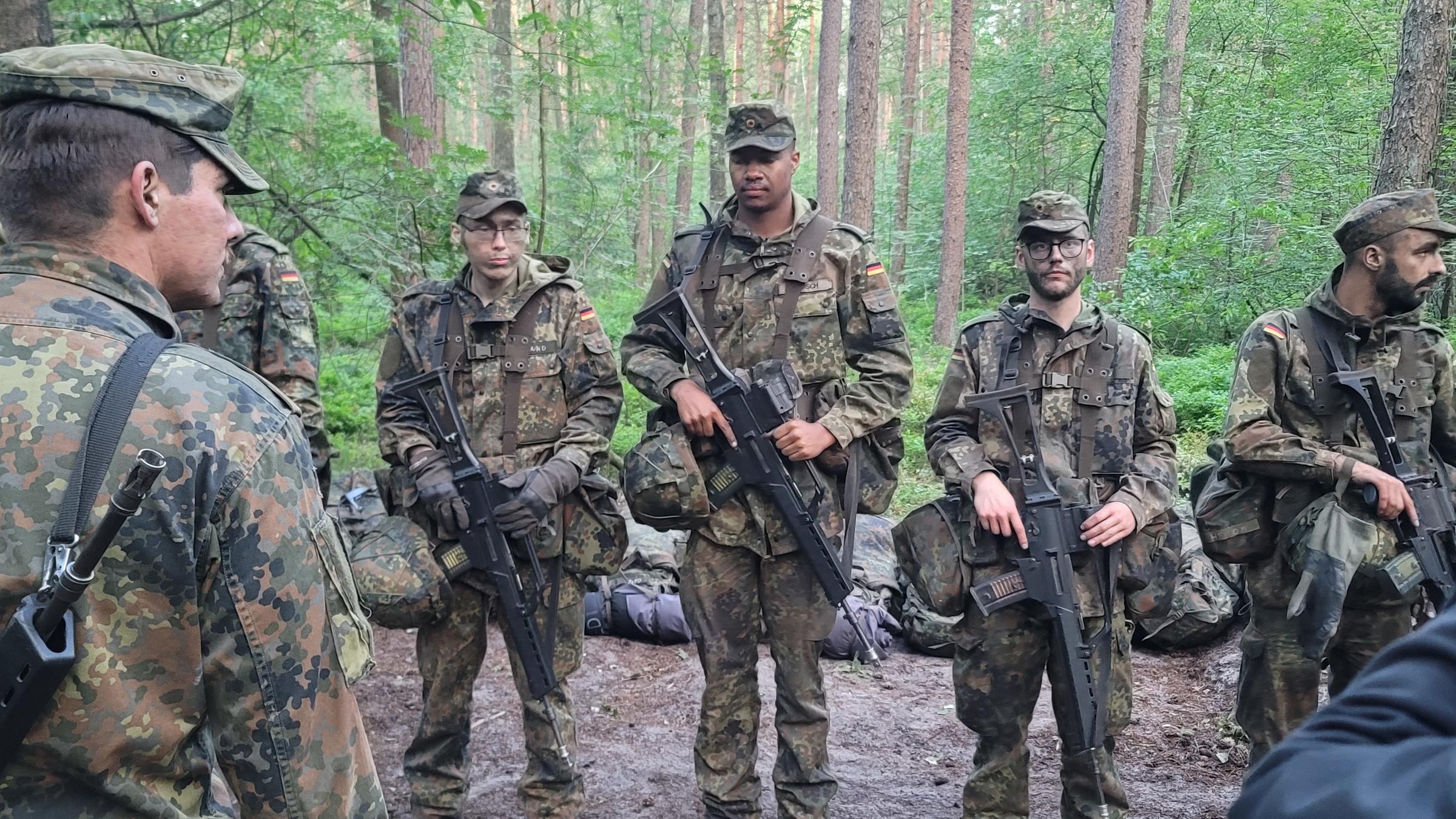 "Beim Bund - Gelöbnis und Karriere": Leon steht bei der Rekrutenbesichtigung mit Kameraden im Wald.