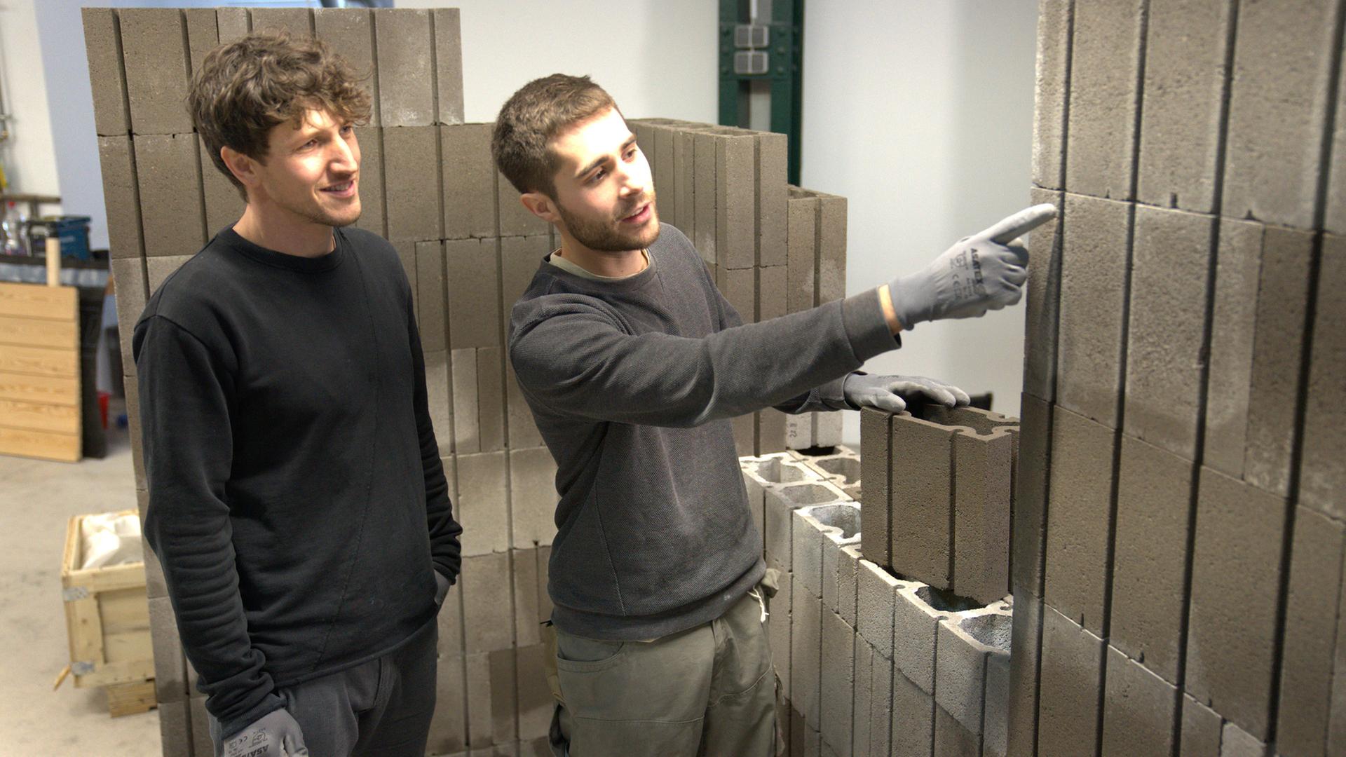 "plan b: Besser bauen - Klimafreundlich in die Zukunft": Zwei Männer, Tibor Bädecker und Robert Rösler, bauen eine Wand mit Sembla-Bausteinen.