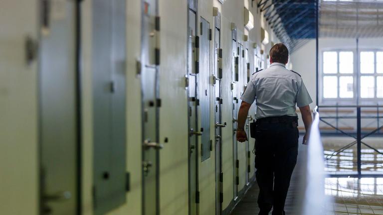 "Knast in Deutschland - Mehr als lebenslänglich": Ein Vollzugsbeamter geht während eines Kontrollgangs in der Justizvollzugsanstalt in Bruchsal an den Zellentüren der Insassen vorbei.