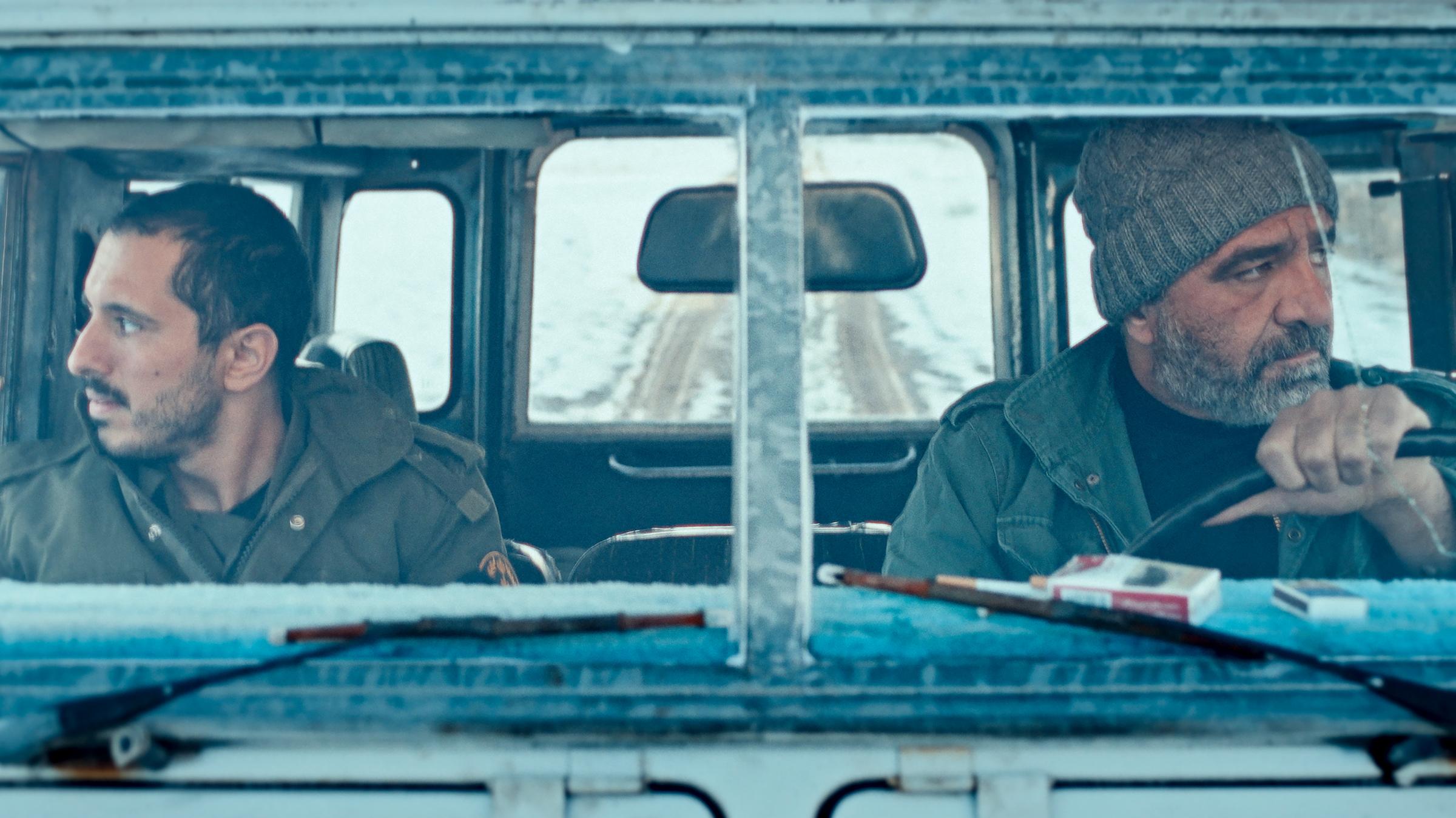 "Everything about a mutual Acquaintance": Ein junger und ein älterer Mann sitzen in einem Auto und blicken in unterschiedliche Richtungen aus dem Fenster.