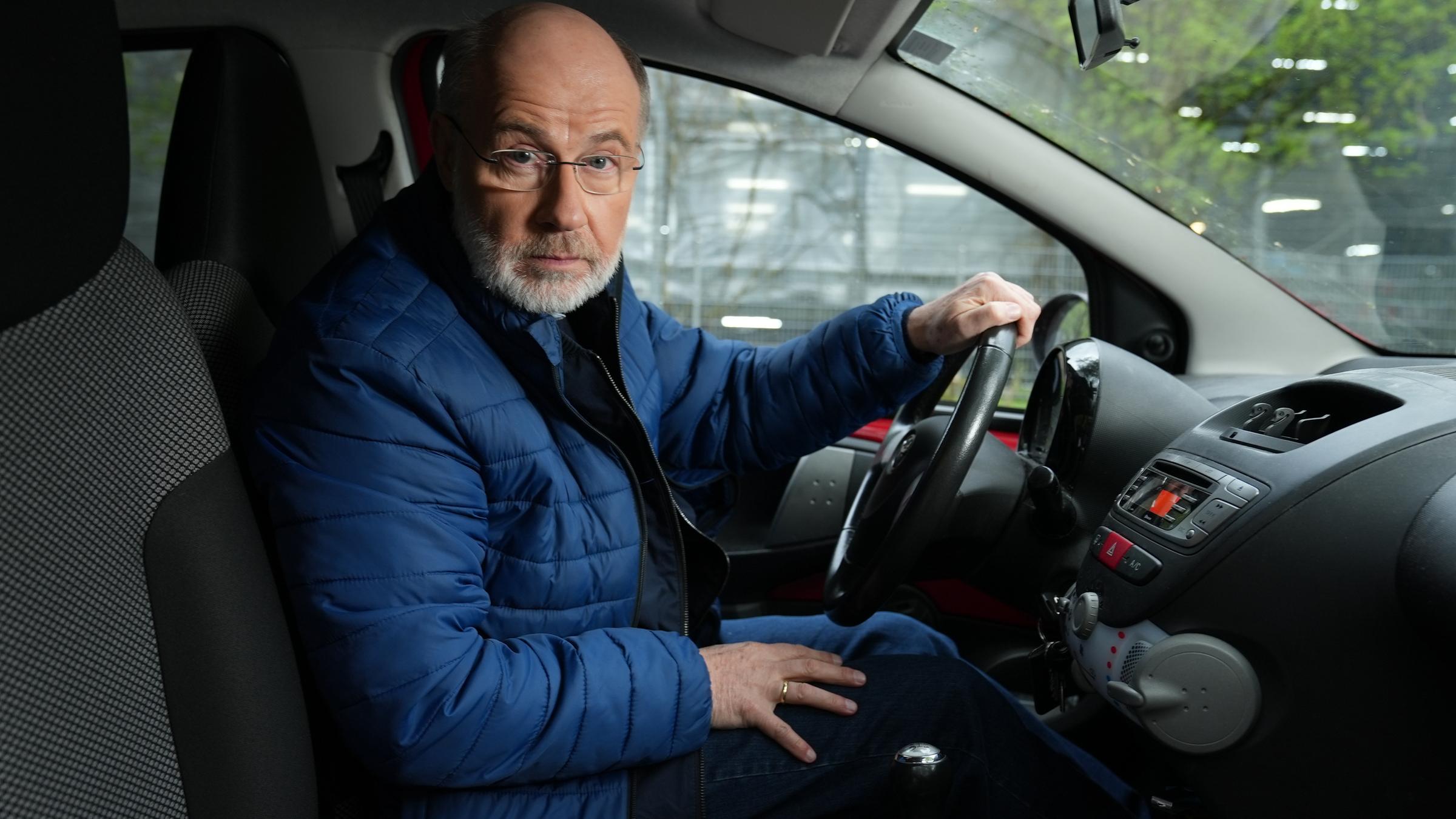 "Terra X Harald Lesch ... und der Streit ums Auto": Harald Lesch sitzt auf dem Fahrersitz und schaut in die Kamera.