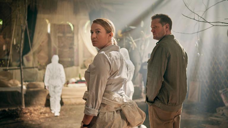 "Theresa Wolff - Lost": Theresa Wolff (Nina Gummich) steht in einem großen Raum mit leichtem Lichteinfall. Neben ihr steht Bruno Lewandowski (Aurel Manthei).