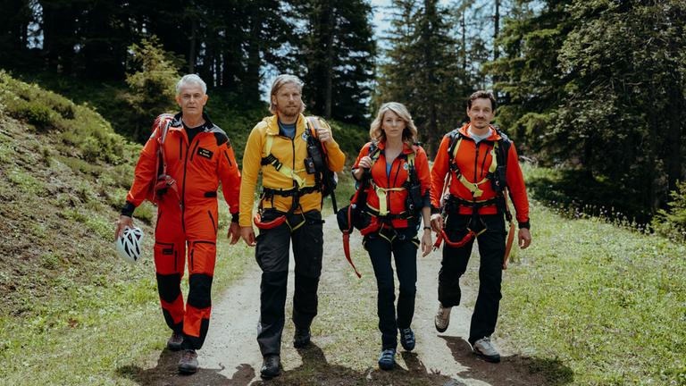 "Die Bergretter: Abschiedsschmerz": Die Bergretter Markus (Sebastian Ströbel), Katharina (Luise Bähr), Tobi (Markus Brandl) und Michi (Robert Lohr) laufen nebeneinander den Berg hinauf.