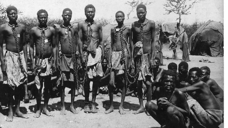 "Der vermessene Mensch - Die Dokumentation": Historisches Schwarz-Weiß-Foto: In Ketten gelegte Herero blicken frontal in die Kamera.