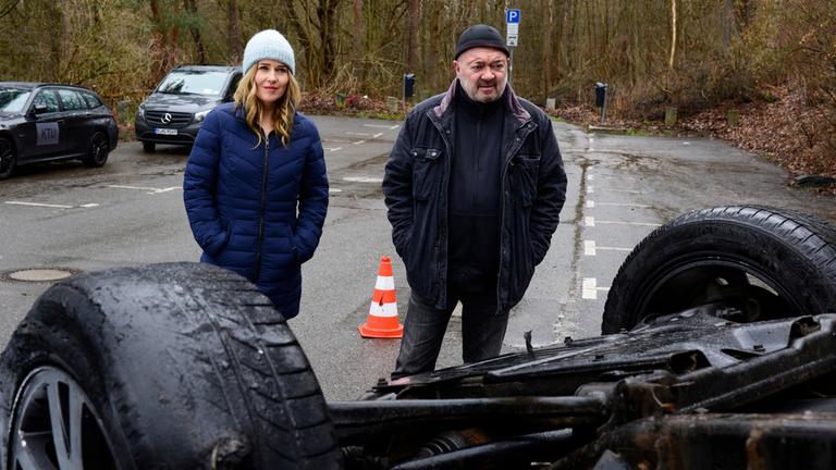 "Ein starkes Team - Verzockt": Linett Wachow (Stefanie Stappenbeck, l.) und Otto Garber (Florian Martens, r.) stehen auf einer abgesperrten Straße. Vor ihnen liegt ein Auto auf dem Dach.