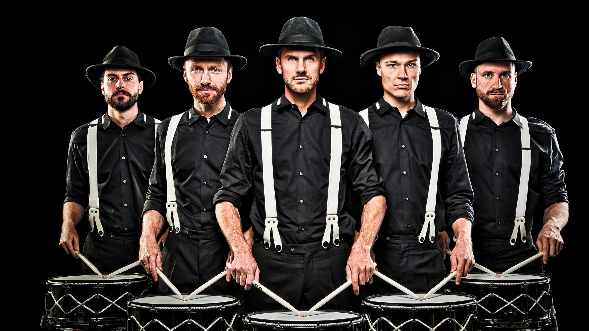  "Die Schlagzeugmafia: Backstreet Noise": Gruppenfoto der 5 trommelnden Männer. Alle sind komplett schwarz gekleidet, tragen weiße Hosenträger und einem schwarzen Hut.