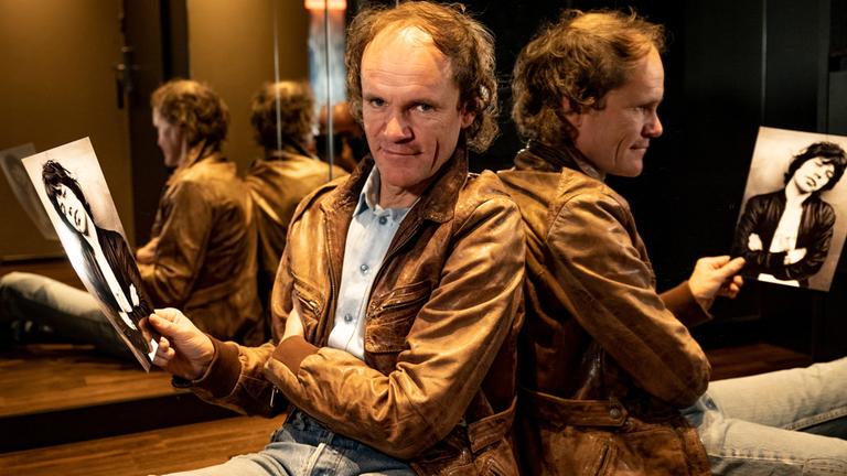 "Olaf Jagger": Olaf Schubert sitzt vor einem Spiegel und hält ein Foto von Mick Jagger in der Hand.