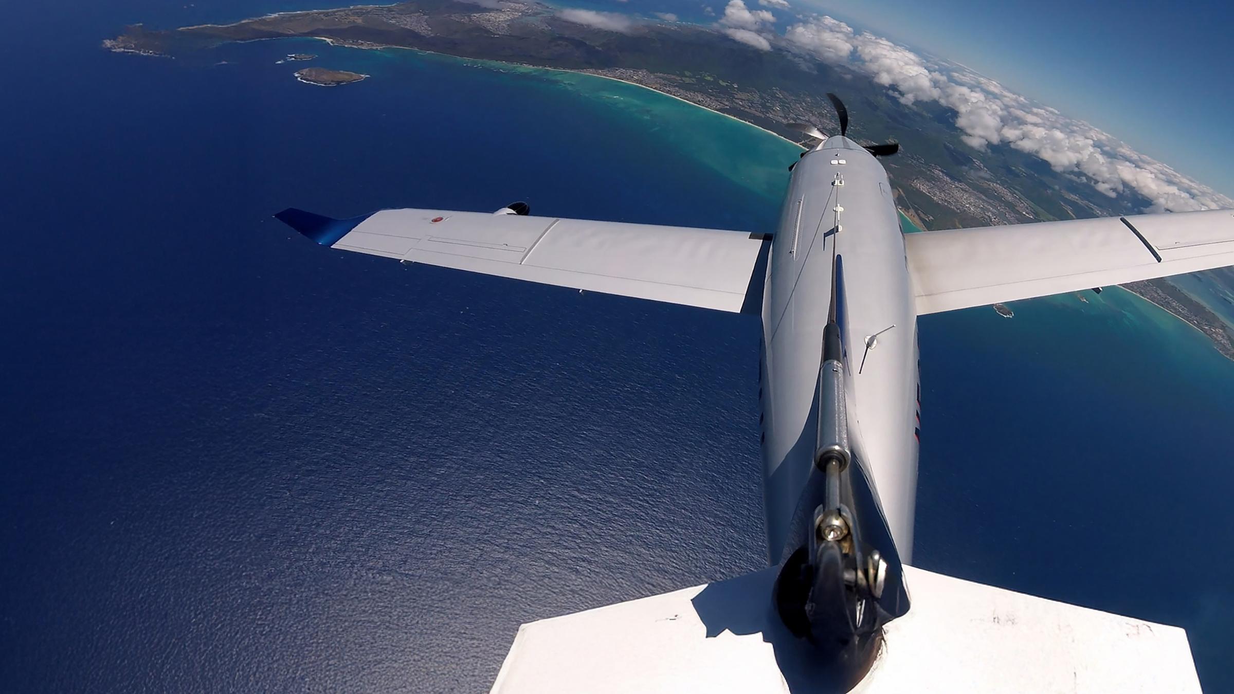 "Schatzinseln im Pazifik - Leben mit dem Ozean (1)": Eine Propellermaschine fliegt über das Meer und einen Landstrich mit Wolken.