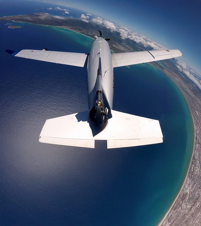 "Schatzinseln im Pazifik - Leben mit dem Ozean (1)": Eine Propellermaschine fliegt über das Meer und einen Landstrich mit Wolken.