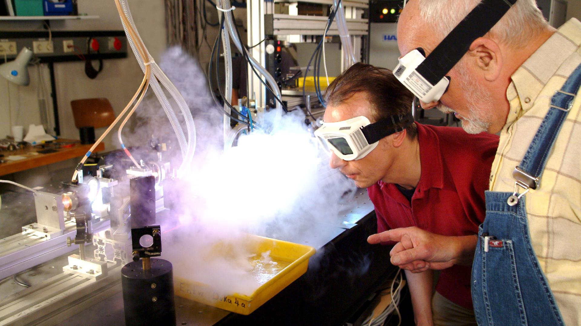 Peter Lustig mit Sichtschutz vor einem Laserstrahl