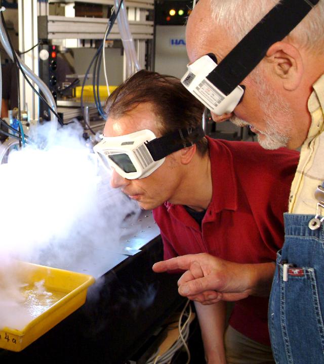 Peter Lustig mit Sichtschutz vor einem Laserstrahl