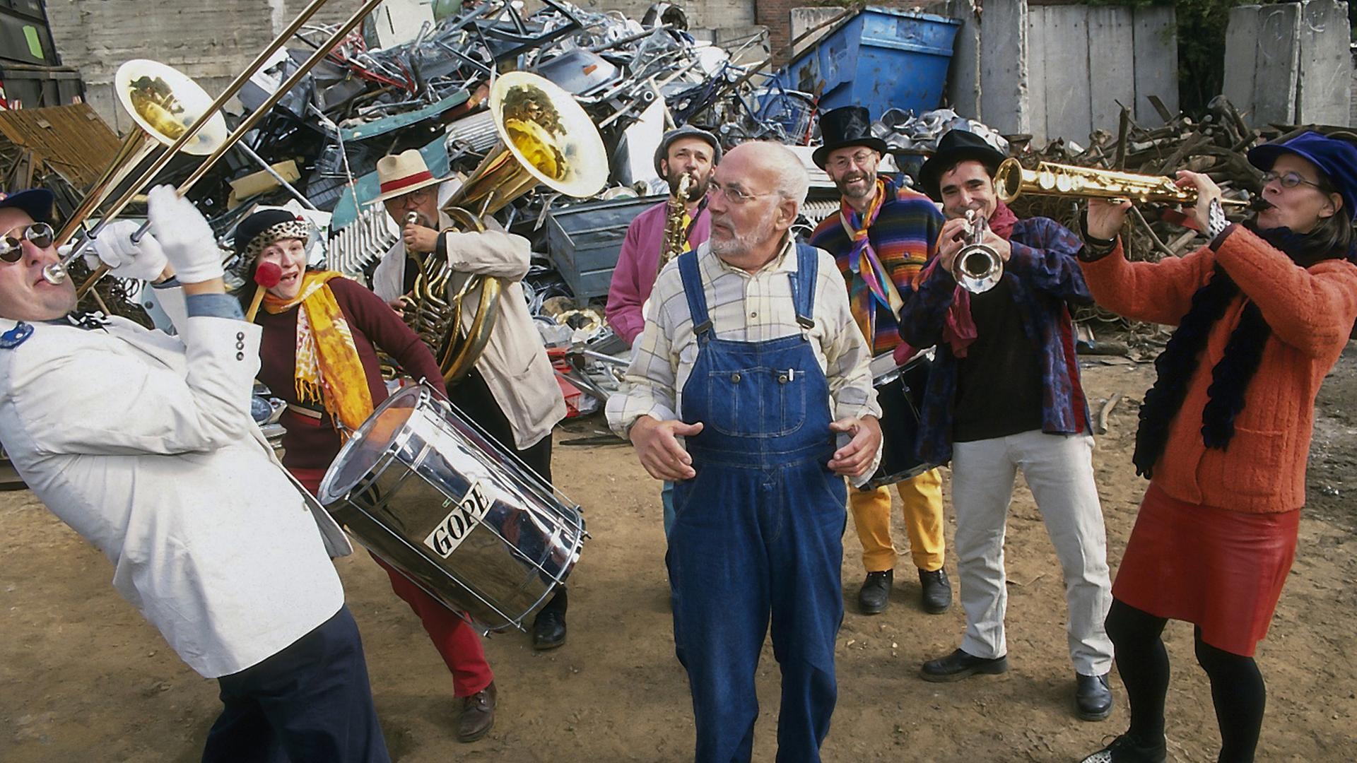 Peter Lustig von Musikern mit Blechinstrumenten umringt