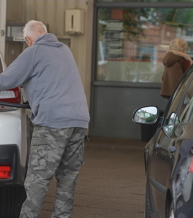 Ein Mann tankt gerade ein Auto.