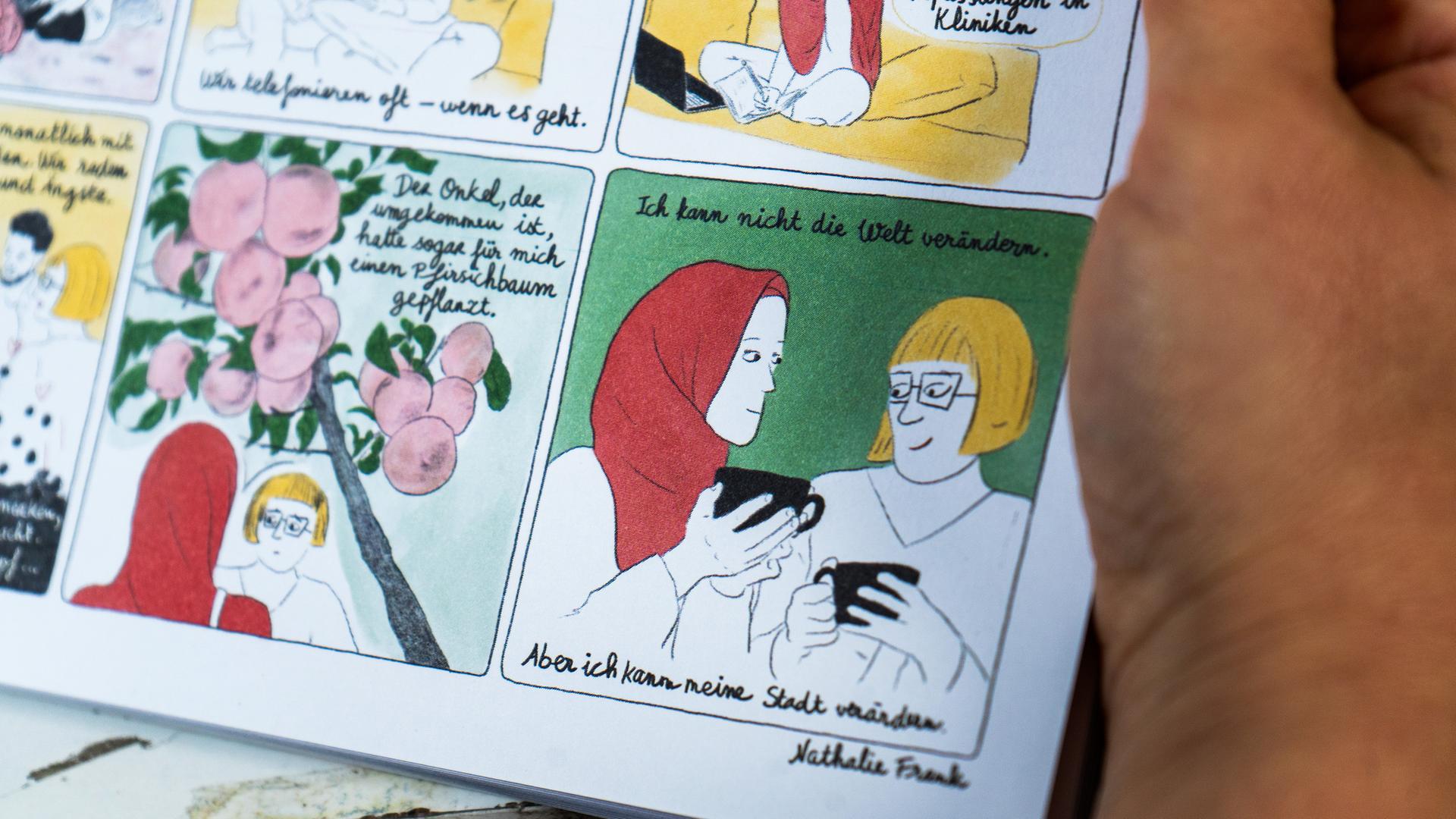 Nahaufnahme einer Comicseite mit zwei Frauen, eine mit rotem Kopftuch, die andere mit blonden Haaren und Brille, beide halten Tassen. Der Text lautet: „Ich kann nicht die Welt verändern. Aber ich kann meine Stadt verändern.“